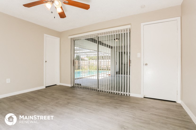 a living room with a sliding glass door to a pool