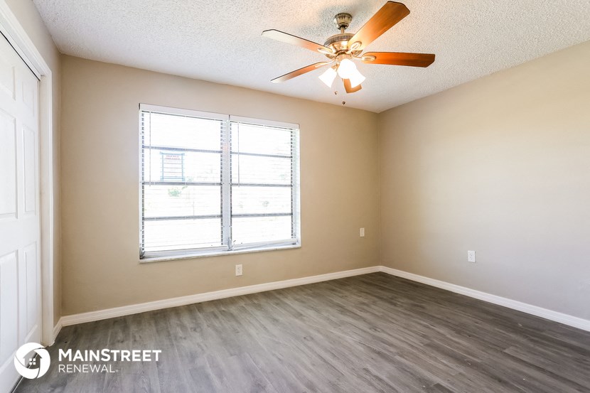 a living room with a ceiling fan and a window