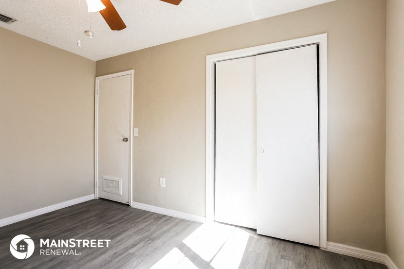 a master bedroom with two closets and a hard wood floor