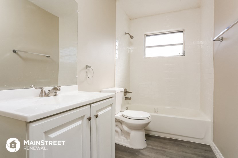 a bathroom with a toilet and a sink and a bath tub