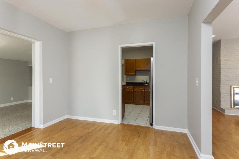 a living room and a kitchen with a wooden floor