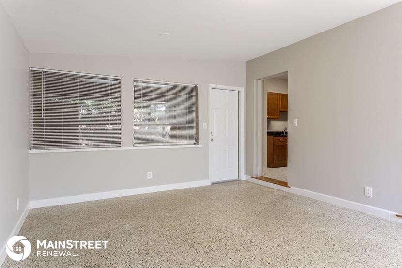 an empty living room with a large window and a door