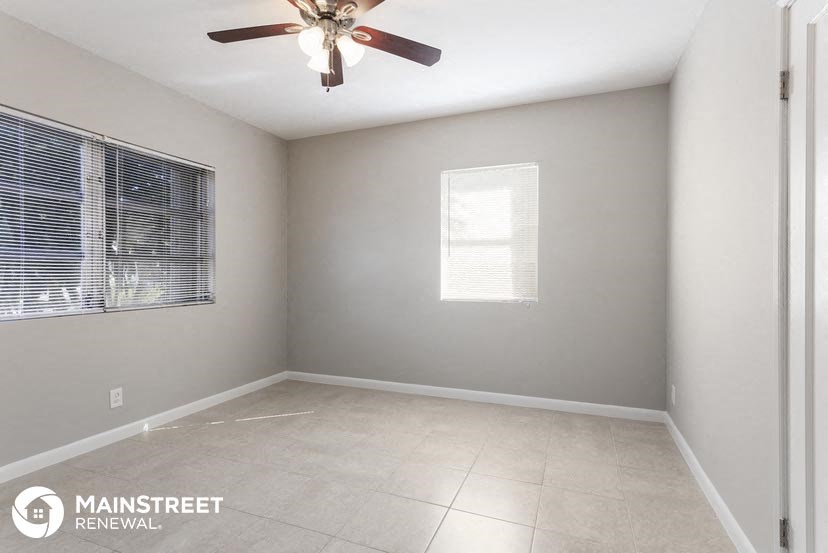 an empty room with a ceiling fan and a window