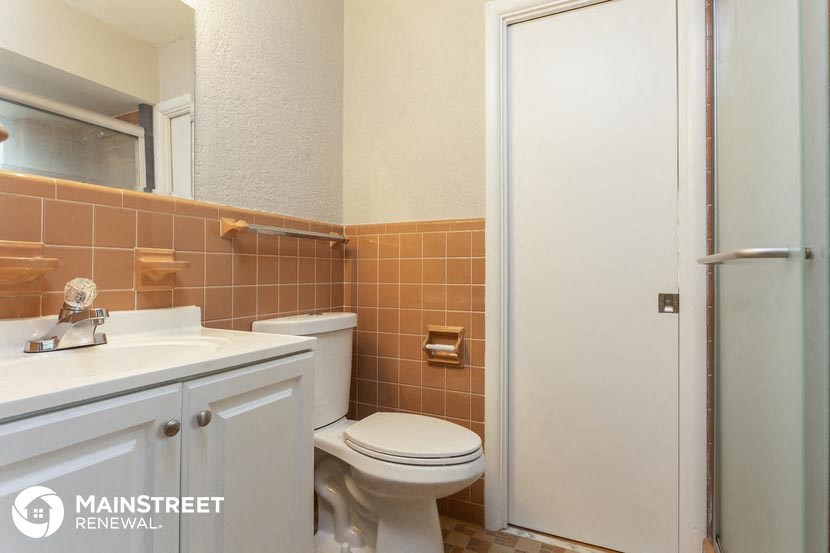 a bathroom with a toilet and a sink and a shower