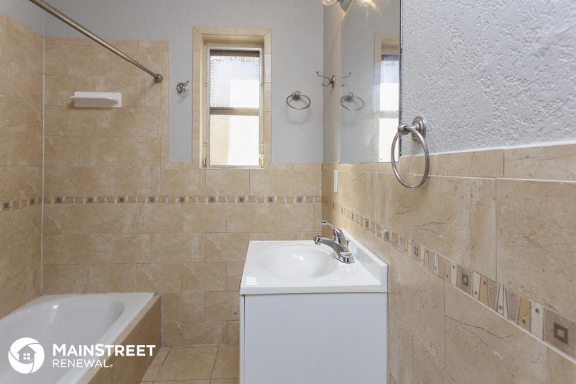 a bathroom with a sink and a tub and a mirror