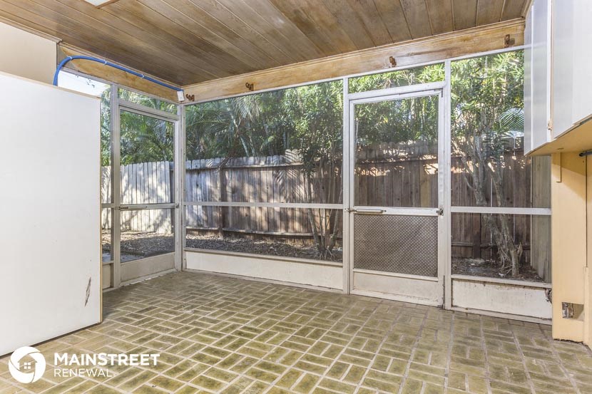 the inside of a screened in porch with glass doors and a fence