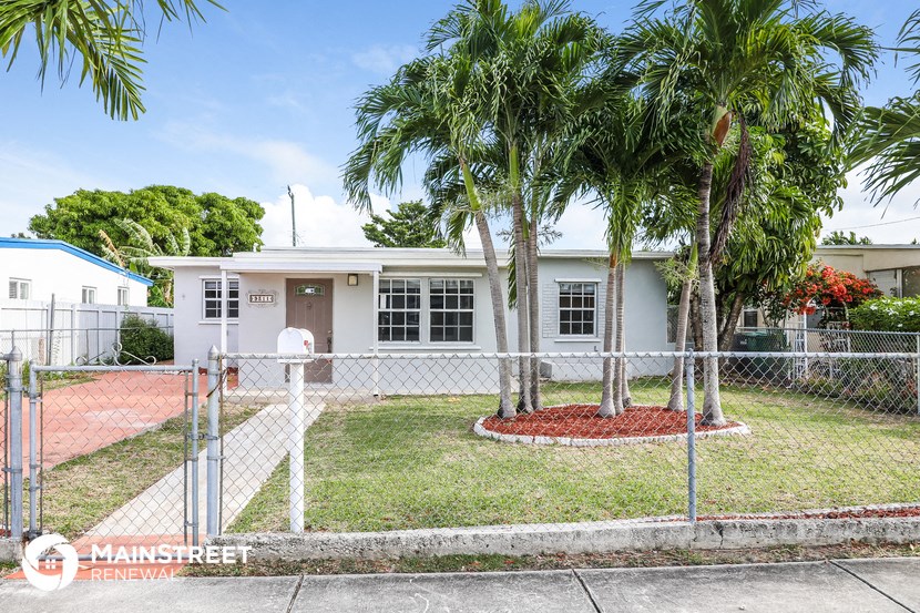 a small white house with palm trees in front of it
