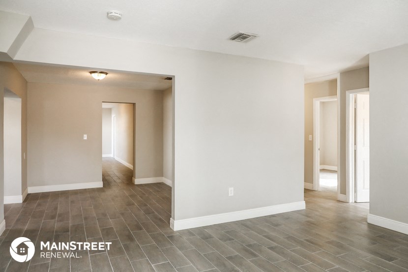 the spacious living room and dining room with tile flooring