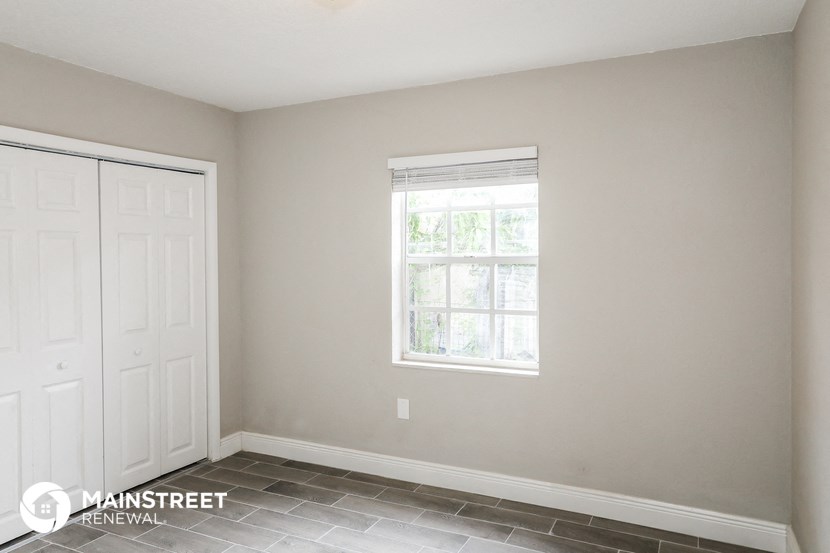 a small room with a window and a white door
