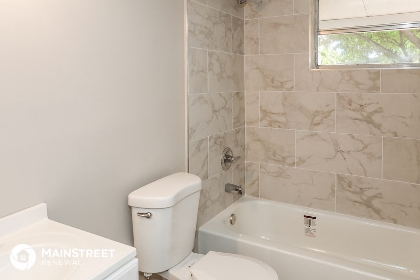 a bathroom with a toilet and a tub and a sink
