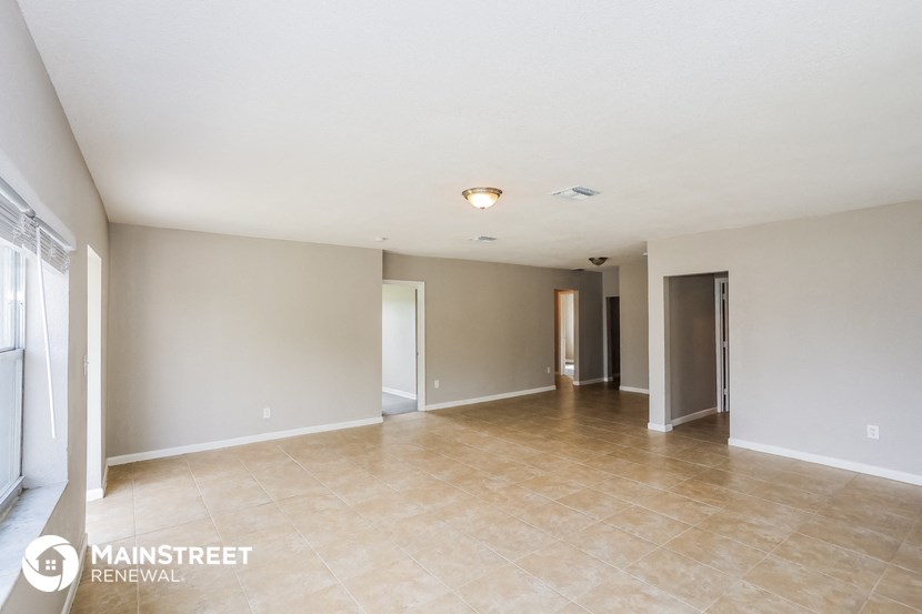 the living room and dining room are spacious with tile floors and neutral walls