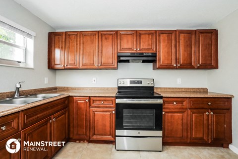 a kitchen with wooden cabinets and a stove and a sink