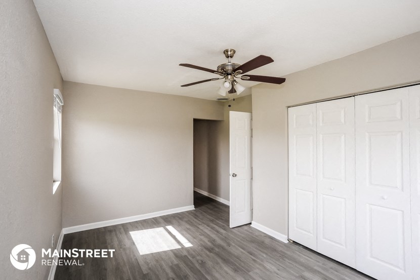 an empty room with a ceiling fan and white doors