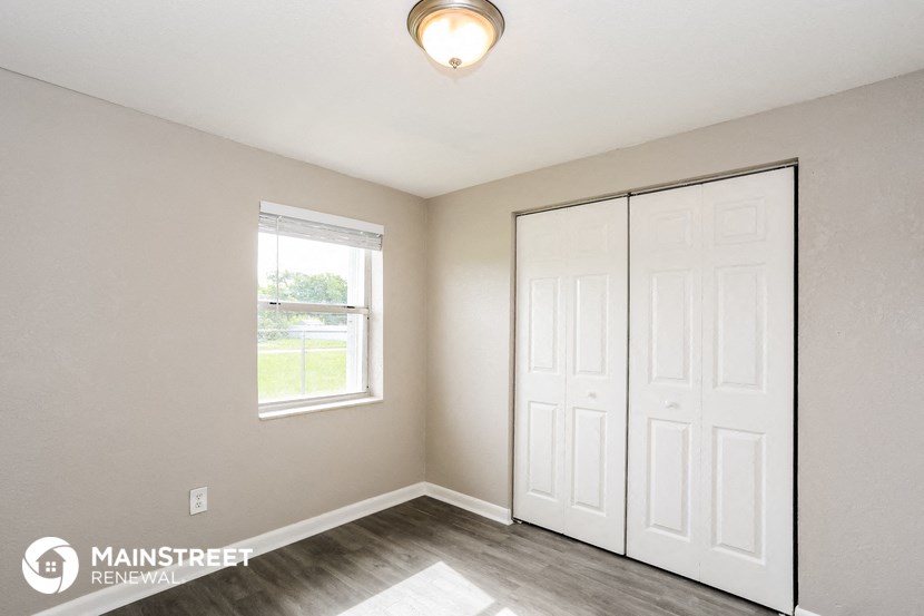 a bedroom with two closets and a window