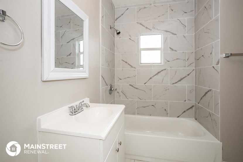 a bathroom with a sink and a bath tub and a mirror