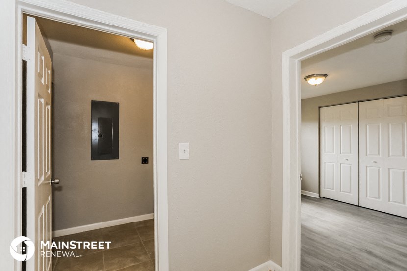 the living room and hallway of a home with a door to the bedroom