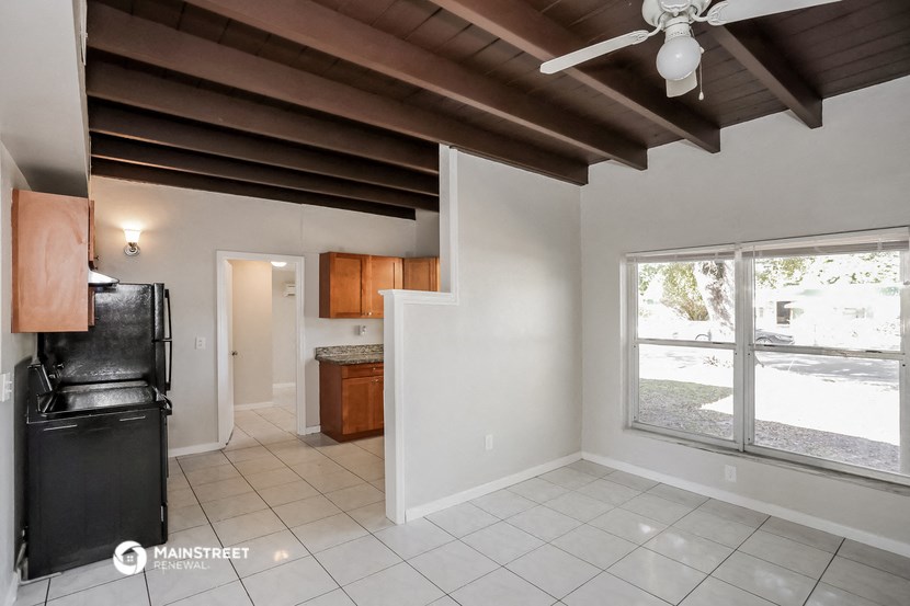 an empty kitchen with a ceiling fan and a large window