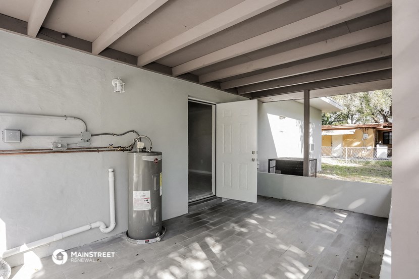 an empty room with a water heater and a door