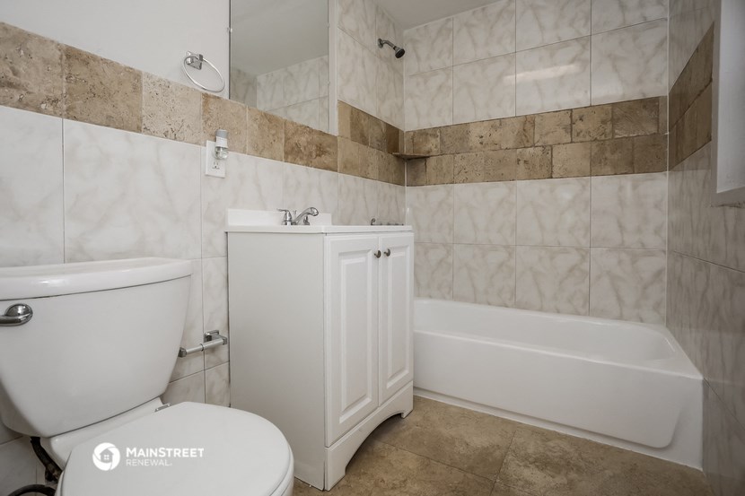 a bathroom with a toilet and a tub and a sink