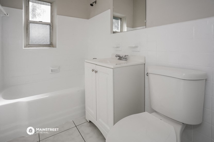 a bathroom with a toilet and a sink and a bath tub
