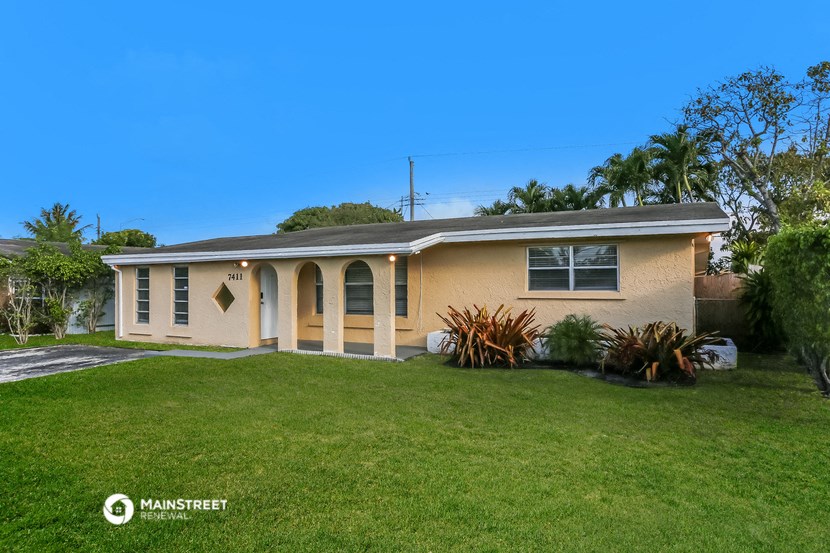 a house with a lawn and a palm tree