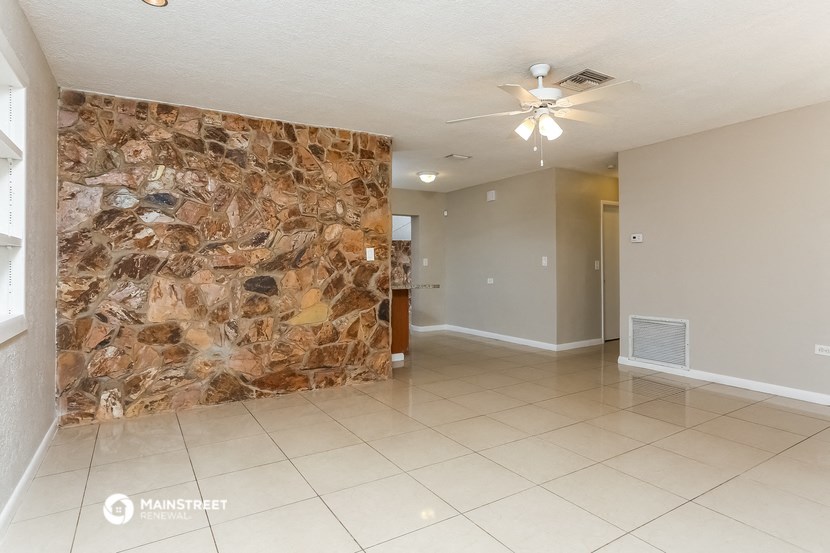 a large living room with a large stone wall in the middle of it