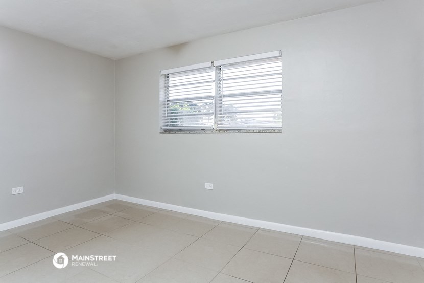 an empty room with a window and a tiled floor
