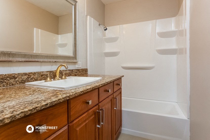 a bathroom with a sink and a tub and a mirror