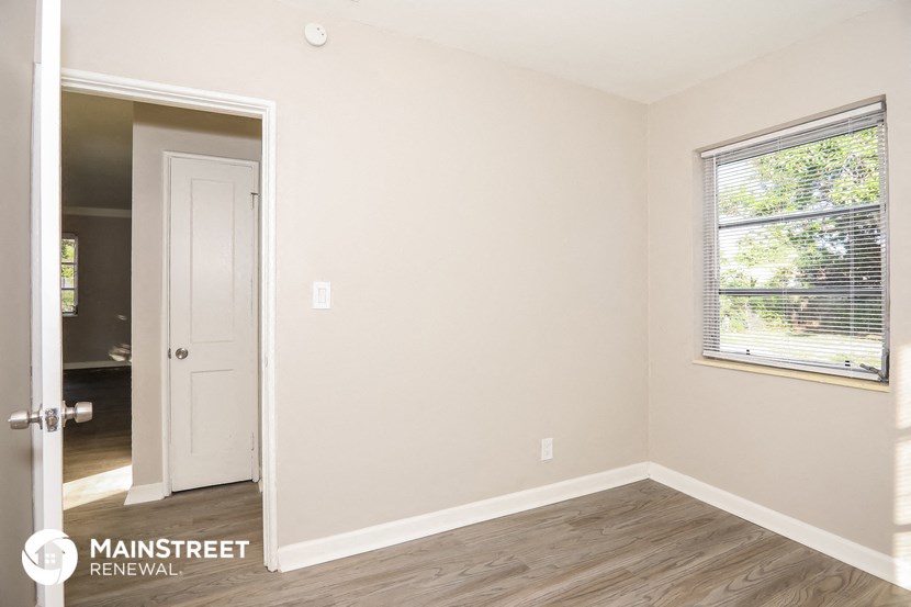 the interior of an empty room with a door and a window