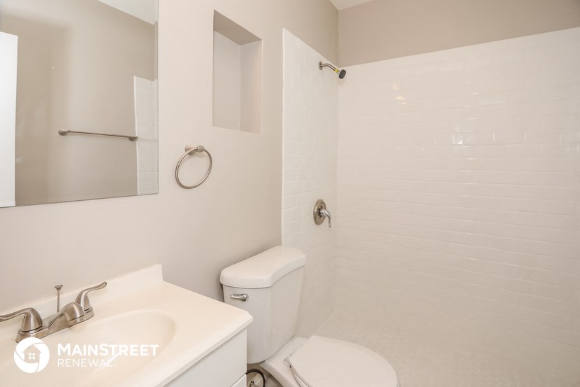 a white bathroom with a toilet and a sink