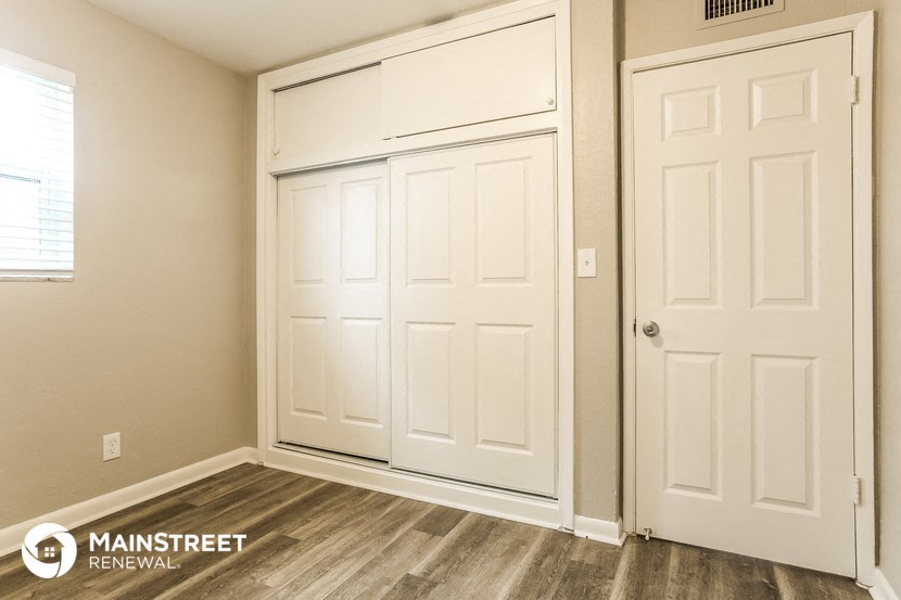 a bedroom with two closets and two doors