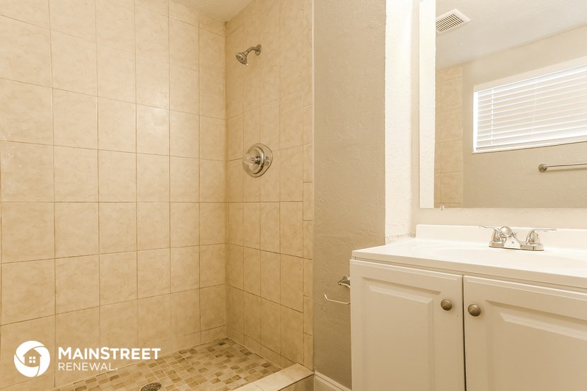 a bathroom with a shower and a sink and a mirror