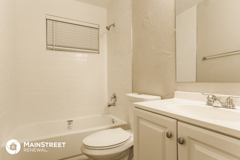 a bathroom with a toilet sink and tub and a mirror