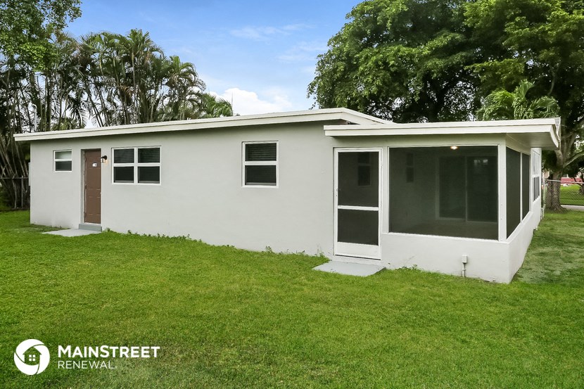 a small white house with a lawn in front of it