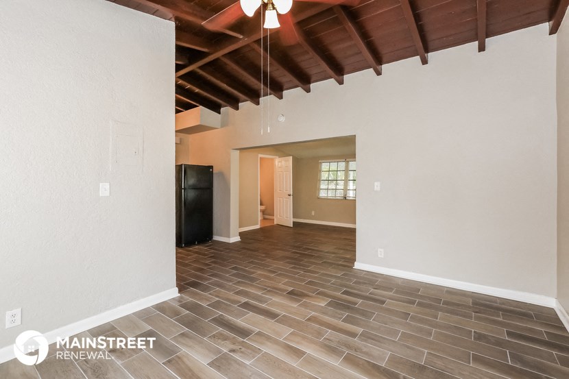 the spacious living room with vaulted ceilings and tile flooring
