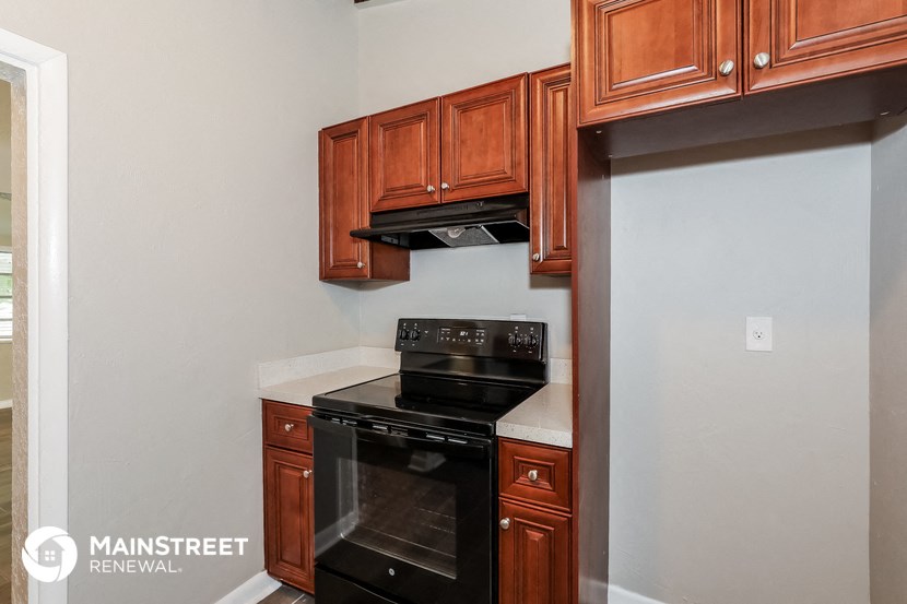 a kitchen with wood cabinets and black appliances and a black stove and oven