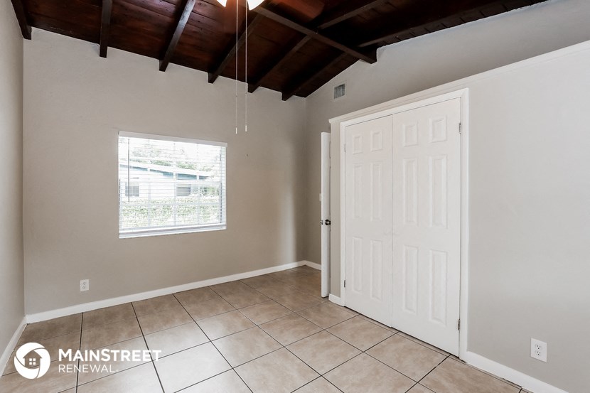 the living room of a home with a tile floor and a white door