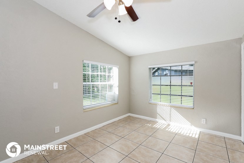the living room has a large window and tile flooring