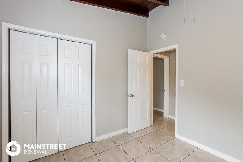 a bedroom with two closets and a door to a hallway