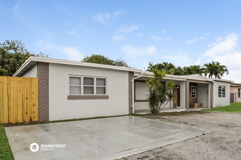 a small white house with a yard and a wooden fence