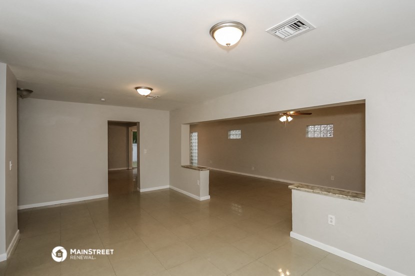 the living room and dining room of an empty apartment
