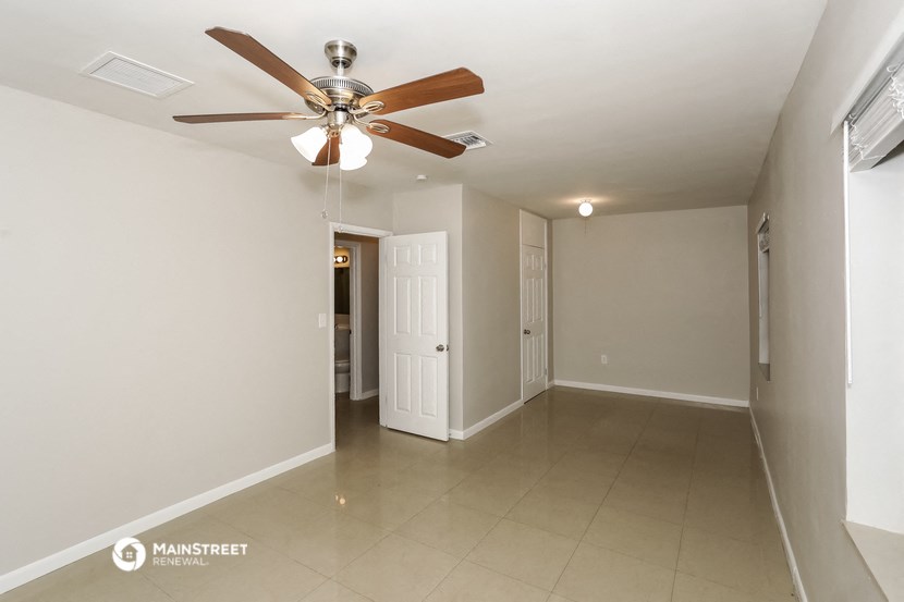 a empty living room with a ceiling fan