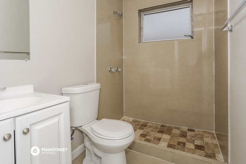 a bathroom with a shower and a toilet and a sink