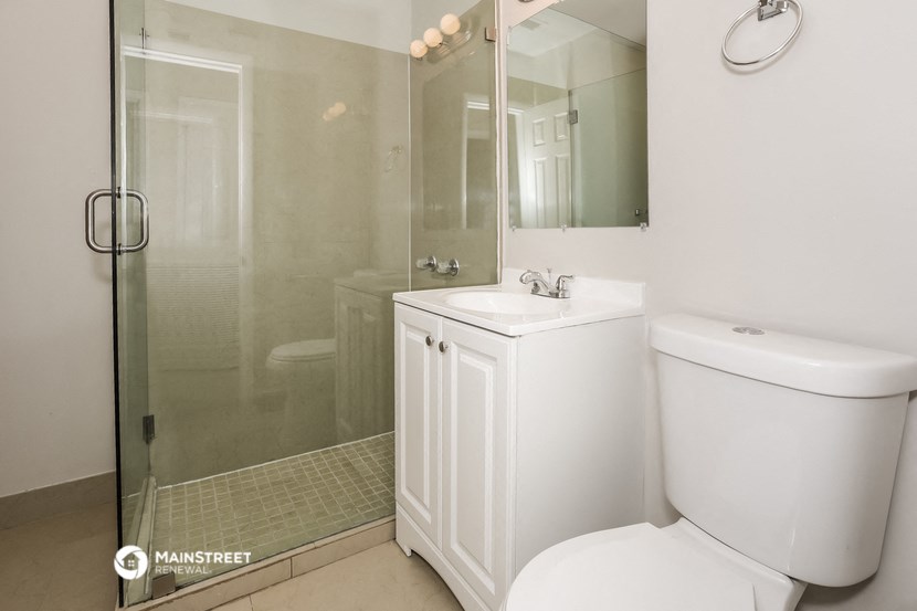 a white bathroom with a shower toilet and sink