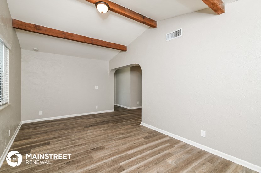 the ceilings in this spacious living room are exposed wood beams