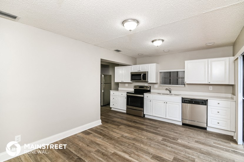 a kitchen with white cabinets and stainless steel appliances