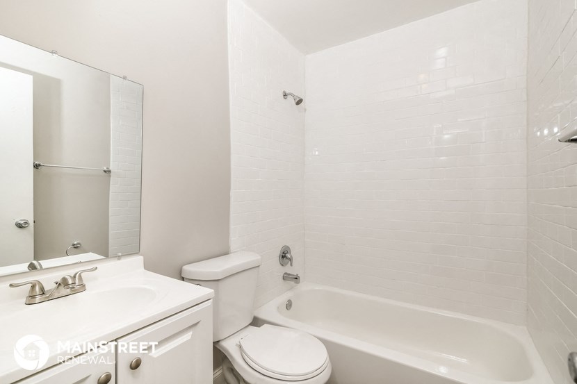 a white bathroom with a toilet sink and bath tub