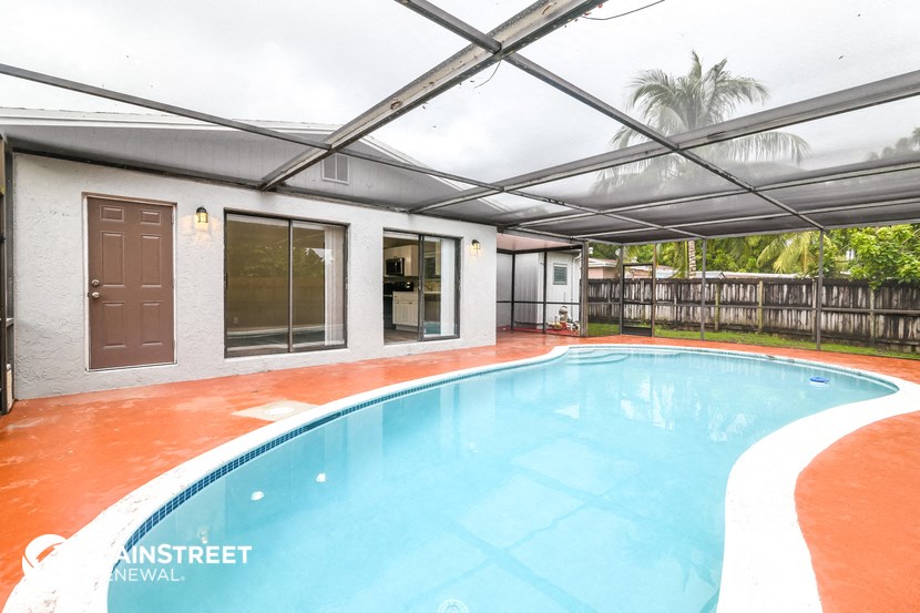 the pool is under an overhead cover in the backyard of a house