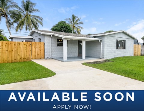a white house with a yard and a wooden fence