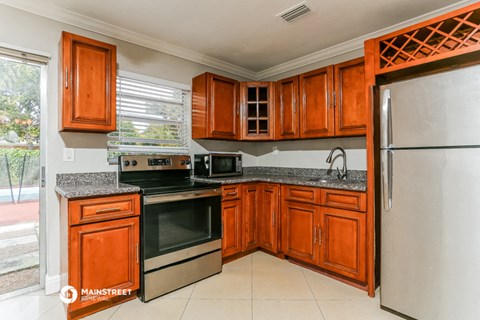 the kitchen is equipped with stainless steel appliances and wooden cabinets